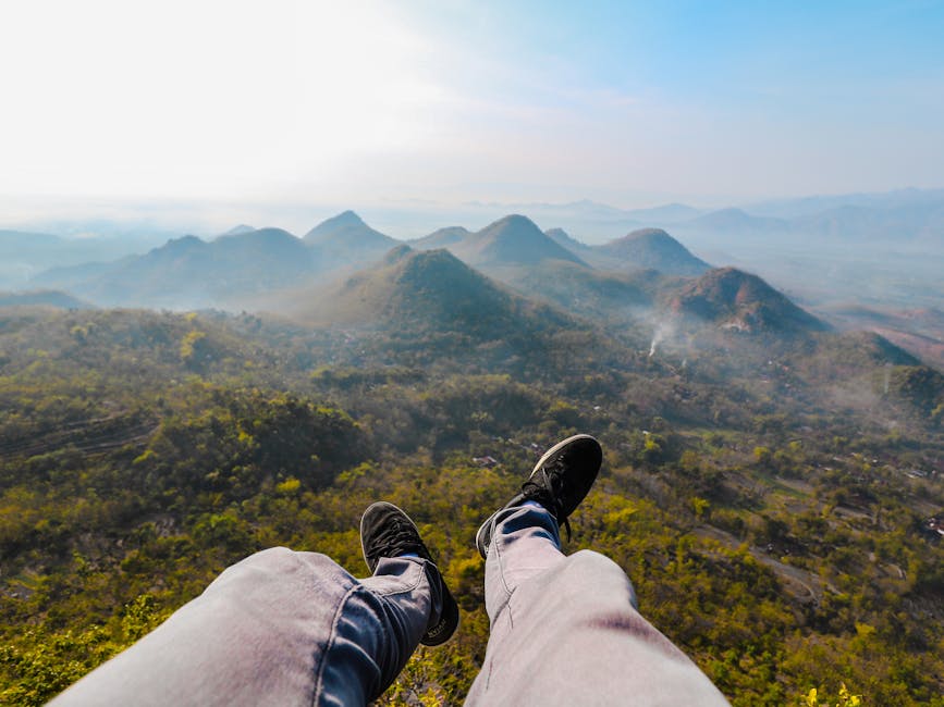 Feet dangling over the stunning landscape of Wonogiri Hills during sunrise, capturing the essence of Indonesian nature
